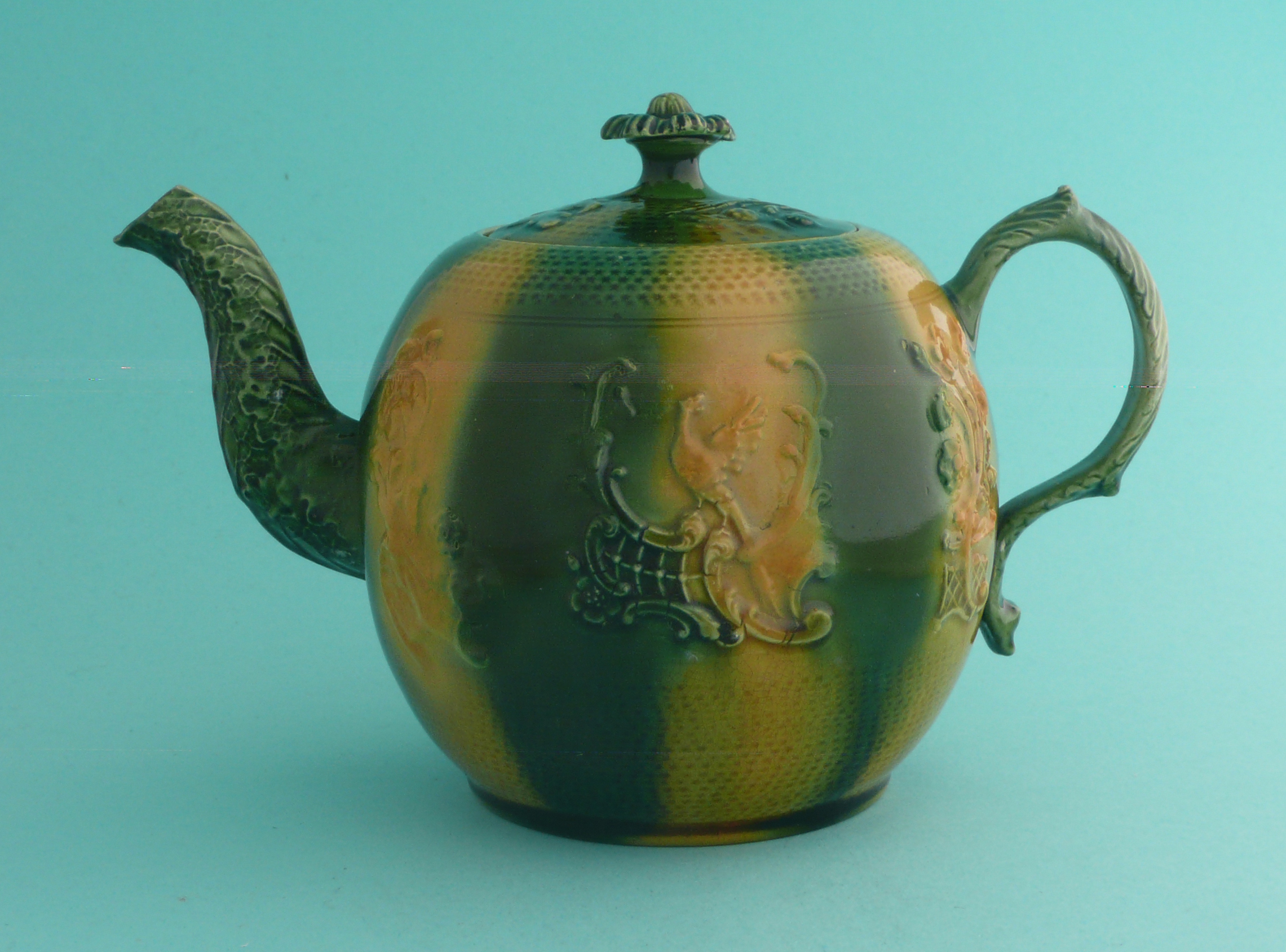 George III and Queen Charlotte: a Whieldon type teapot and cover with floral knop, moulded with