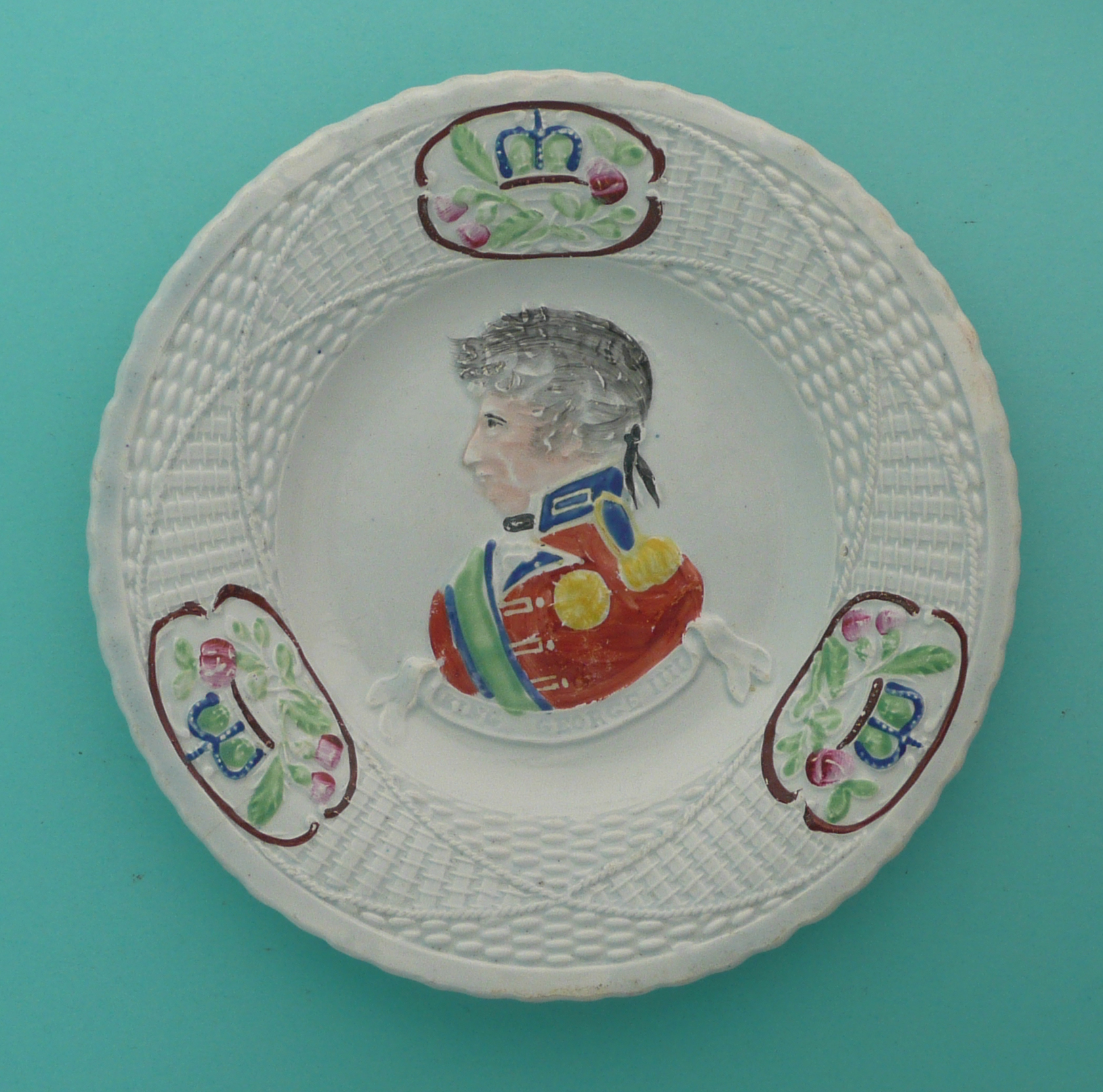 George IV: a Scottish pottery nursery plate well moulded and coloured with a named profile, circa