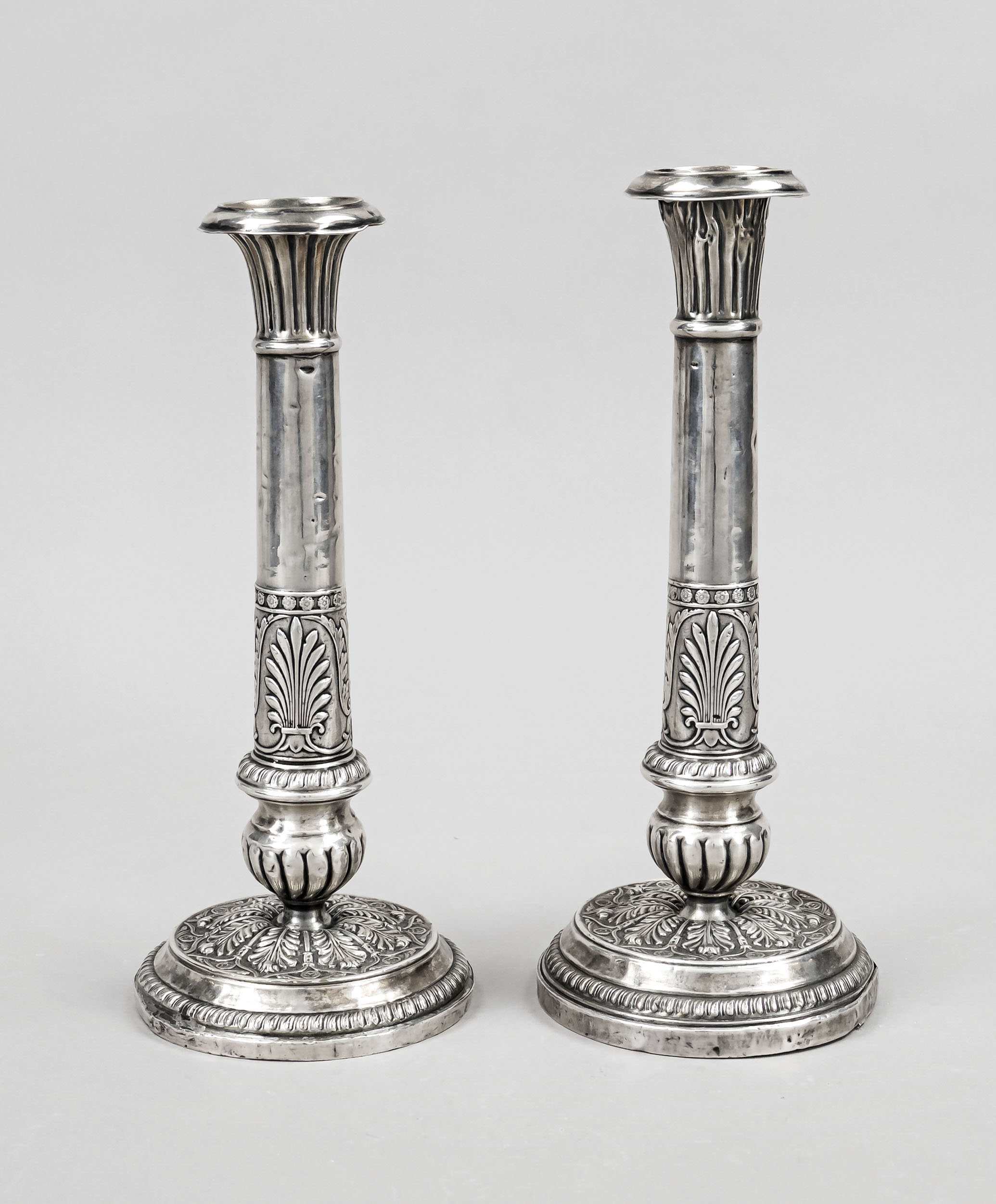 Pair of candlesticks, circa 1900, silver tested, round stand, column shaft, wall with relief