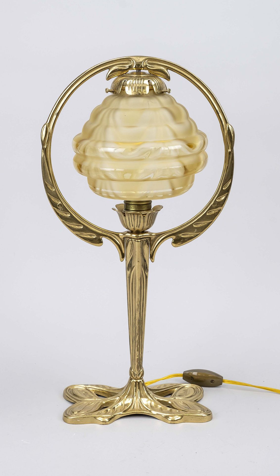 Table lamp, mid 20th century, organically shaped brass stand, profiled shade of yellowish glass,