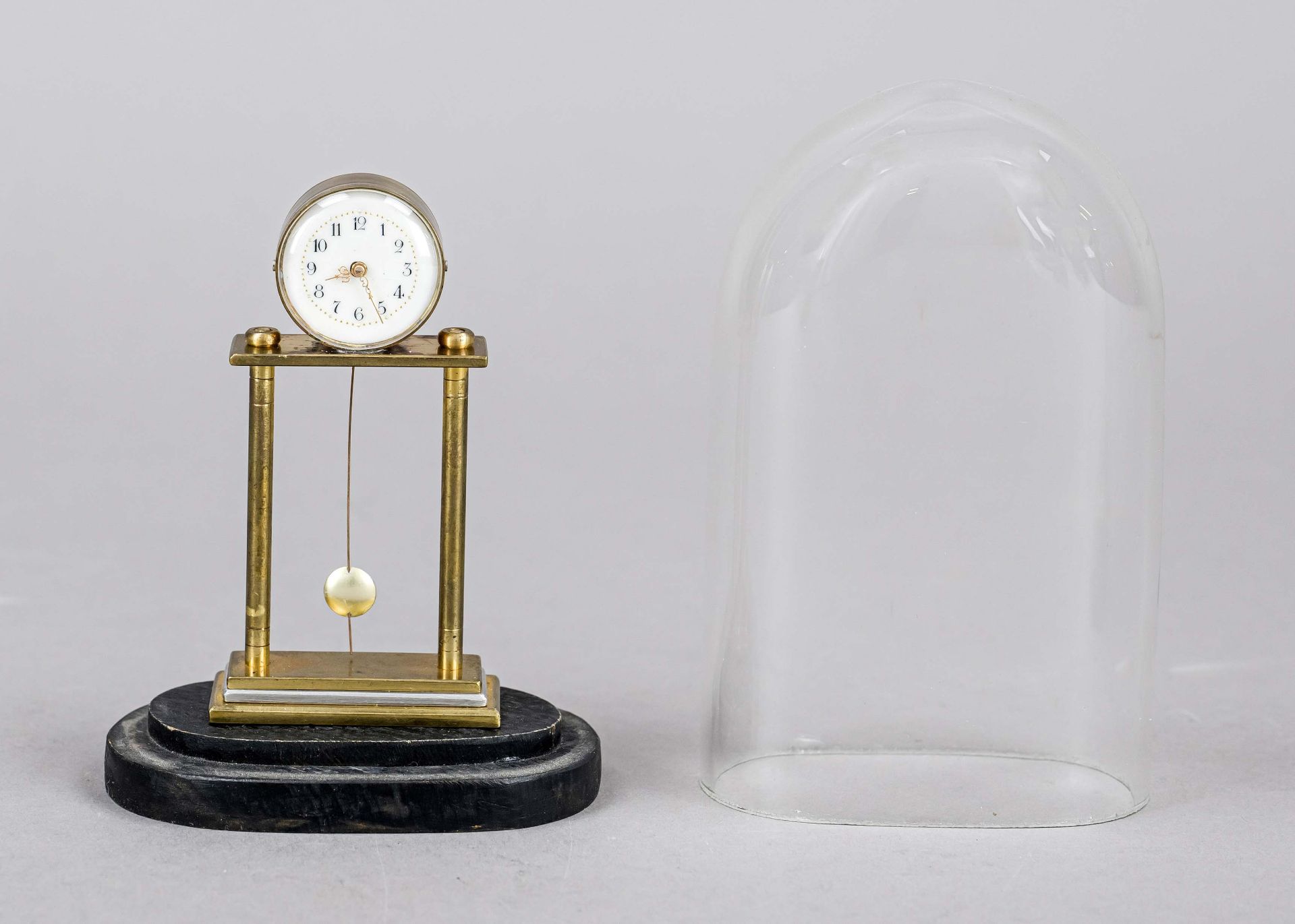 Miniature portal clock, brass, under oval glass dome on ebonized base, 20th century, white enamel - Image 2 of 2