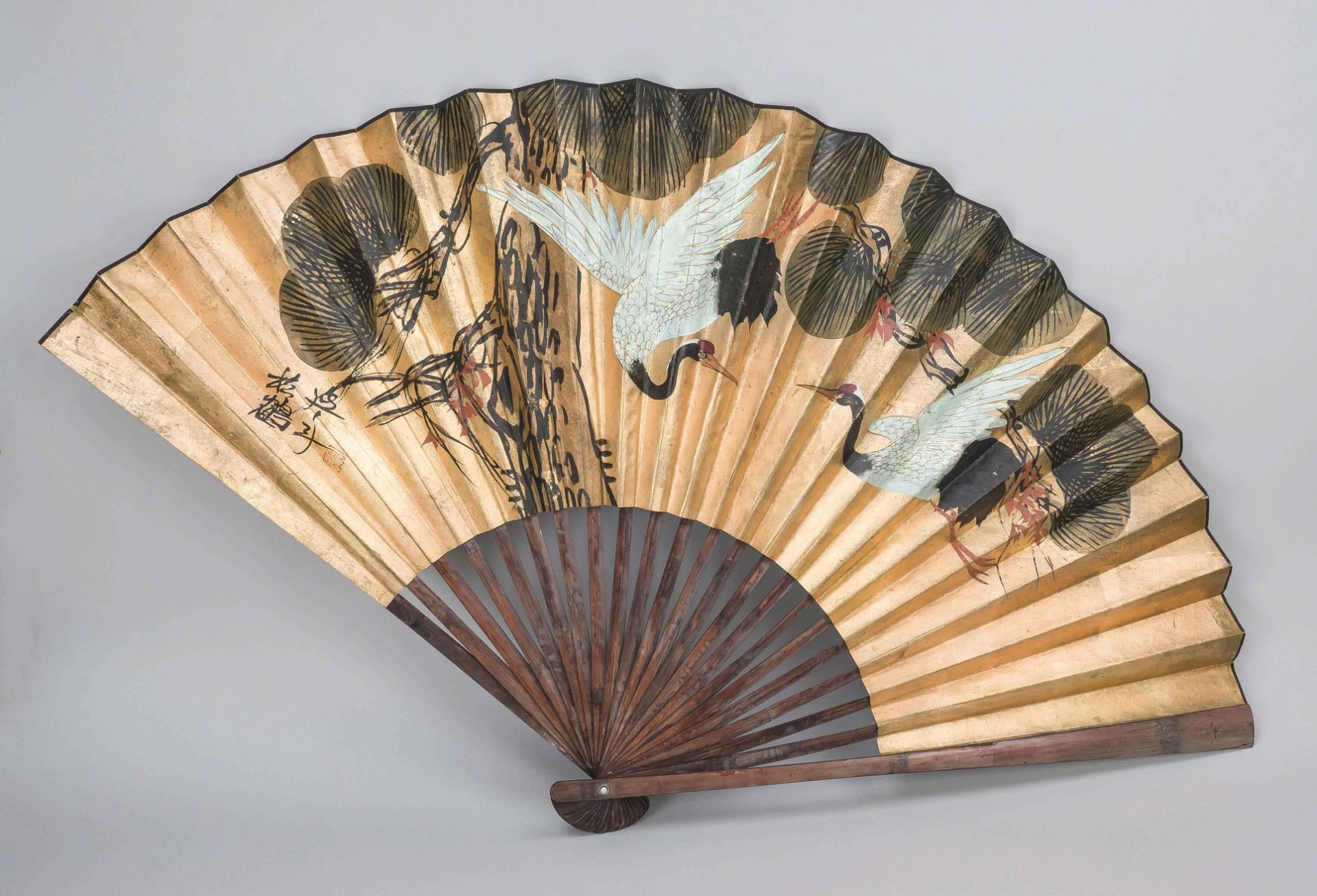 Large fan, China 20th century, cranes on a golden ground, artist's mark. Slightly rubbed, l. 70 cm