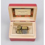 Small music box, Switzerland 20th century, Reuge. Red lacquered box with Mozart medal. Inside