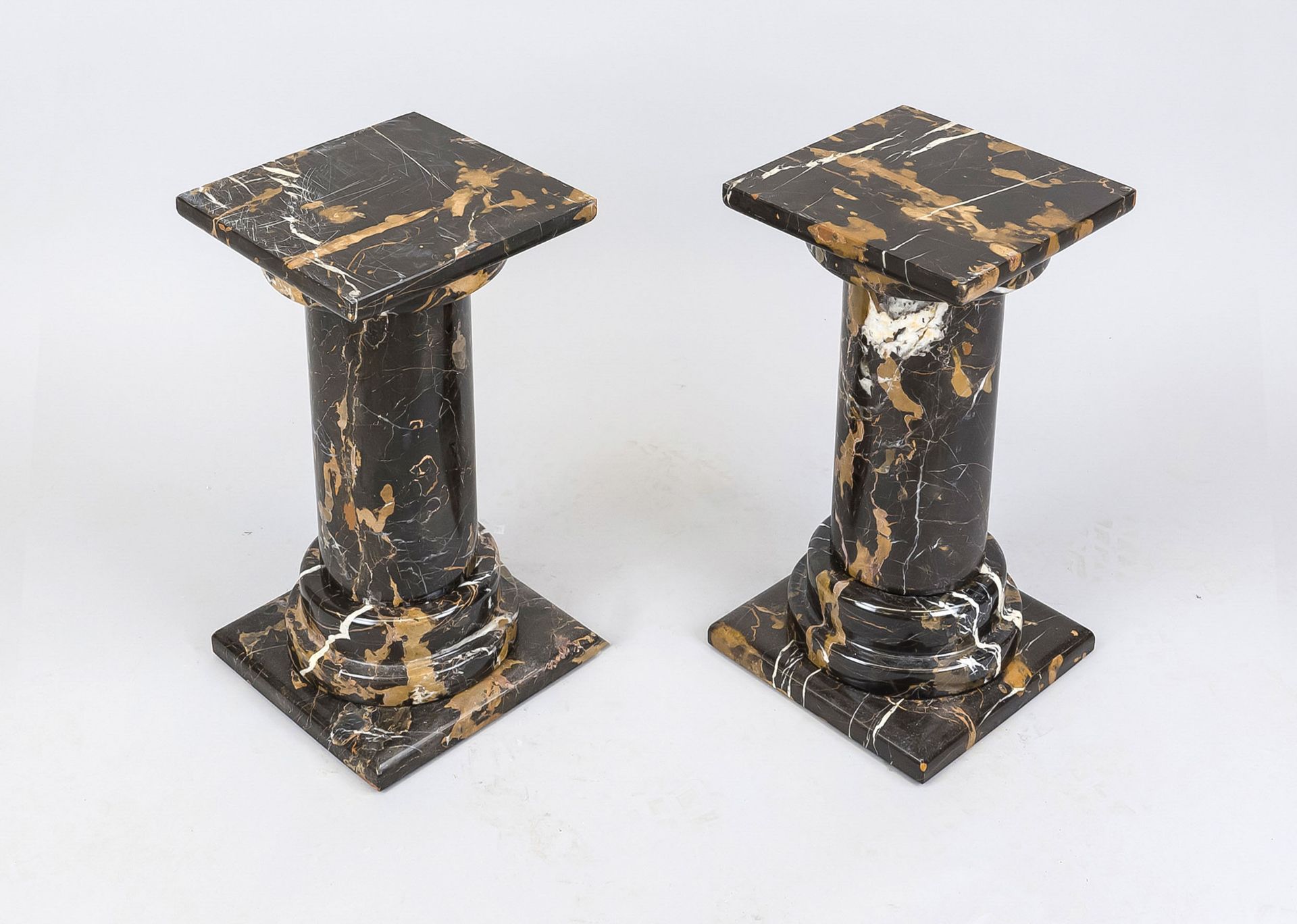 A pair of reeded flower columns, 20th century, polished black stone with natural polychrome pattern,