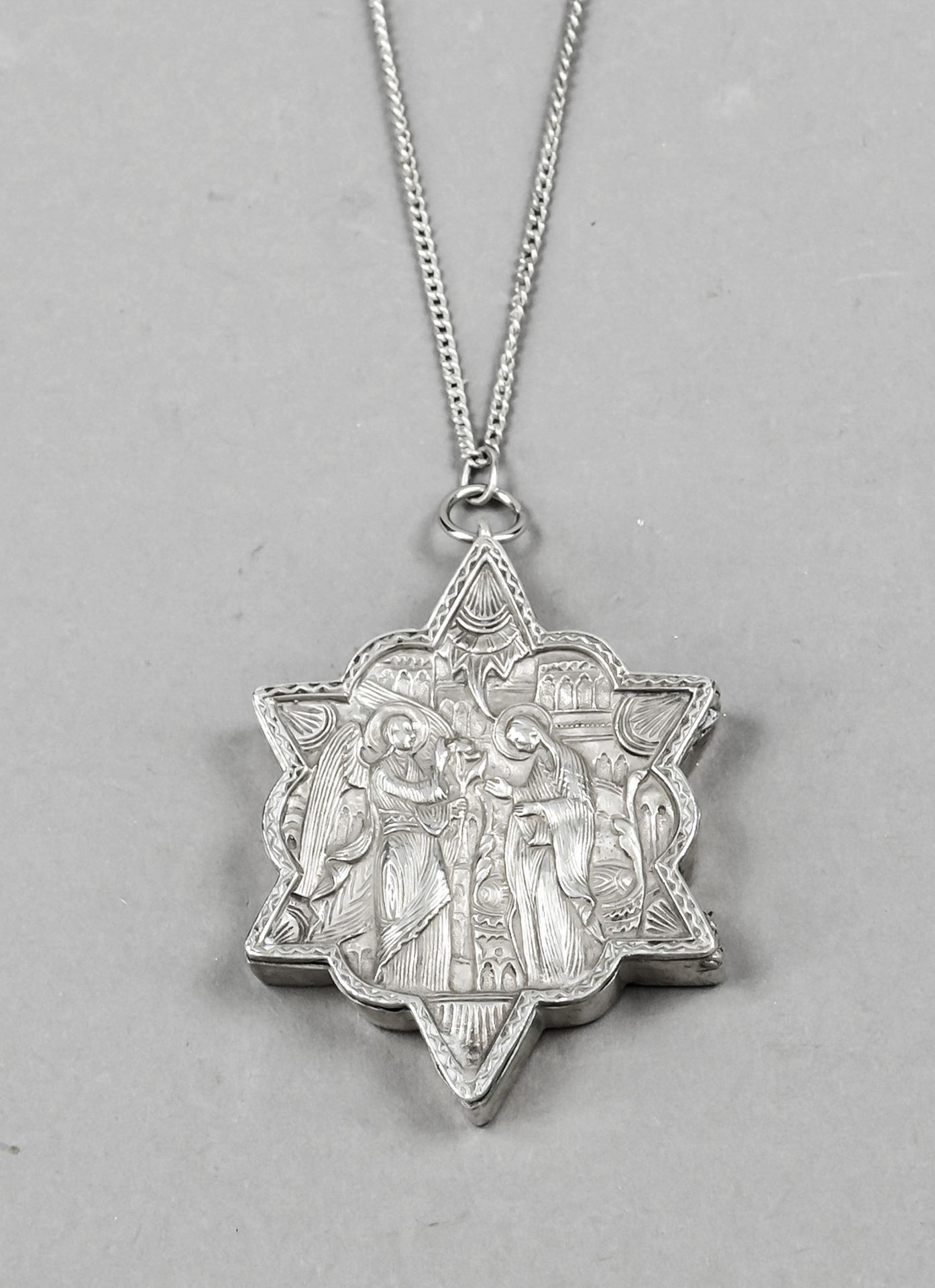 Star-shaped medallion, 19th century, silver tested, hinged, front with sacral, figurative relief