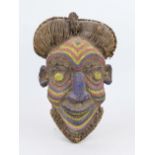 African mask, carved wood, decorated with various materials such as earth, beads, jute etc., h. 45