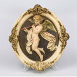 Flute playing angel, late 19th century, ceramic polychrome painted. Profiled, oval frame with