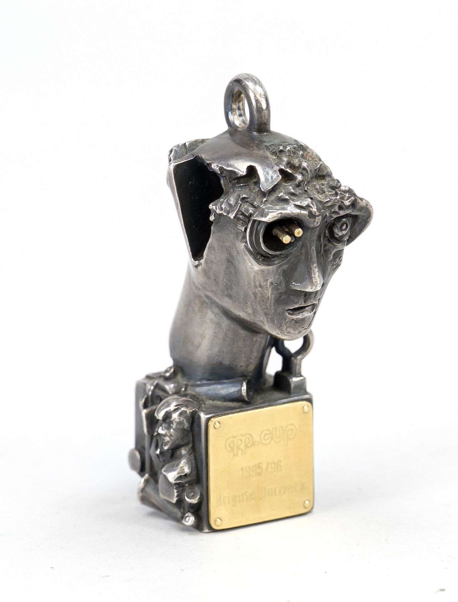 Futuristic head, cast silver. Gilt, engraved metal plaque on the front, monogrammed 'CH' on the