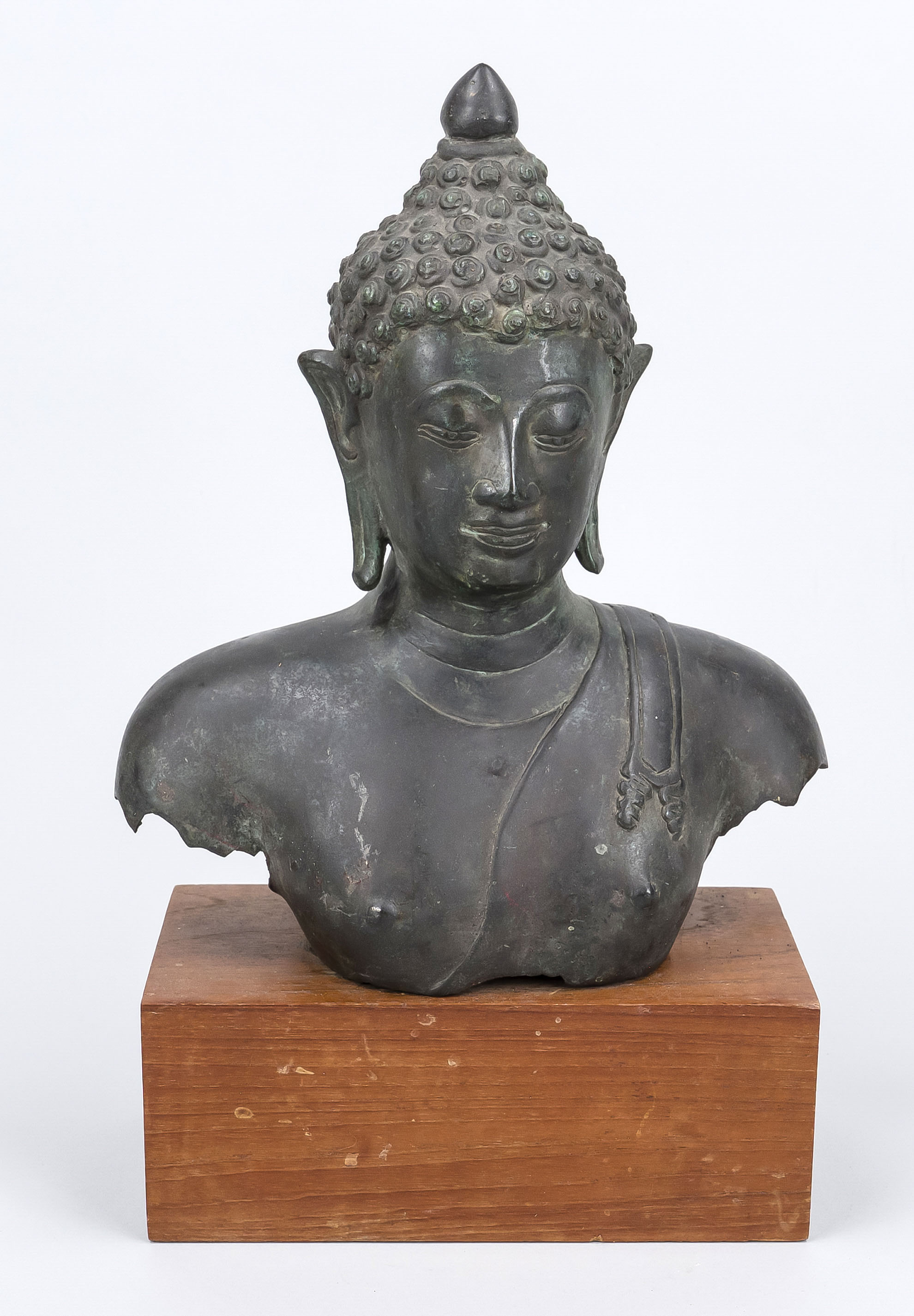 Buddha bust/fragment, exact age and origin uncertain, bronze. Mounted on a rectangular wooden