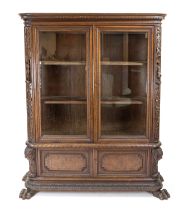 Display cabinet, circa 1930, walnut, 4-door, glazed body on paw feet, carved sides with sculptural