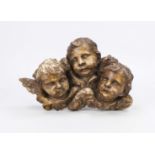 3 Putti Heads, 18th century, carved limewood, probably formerly part of a larger group, small iron