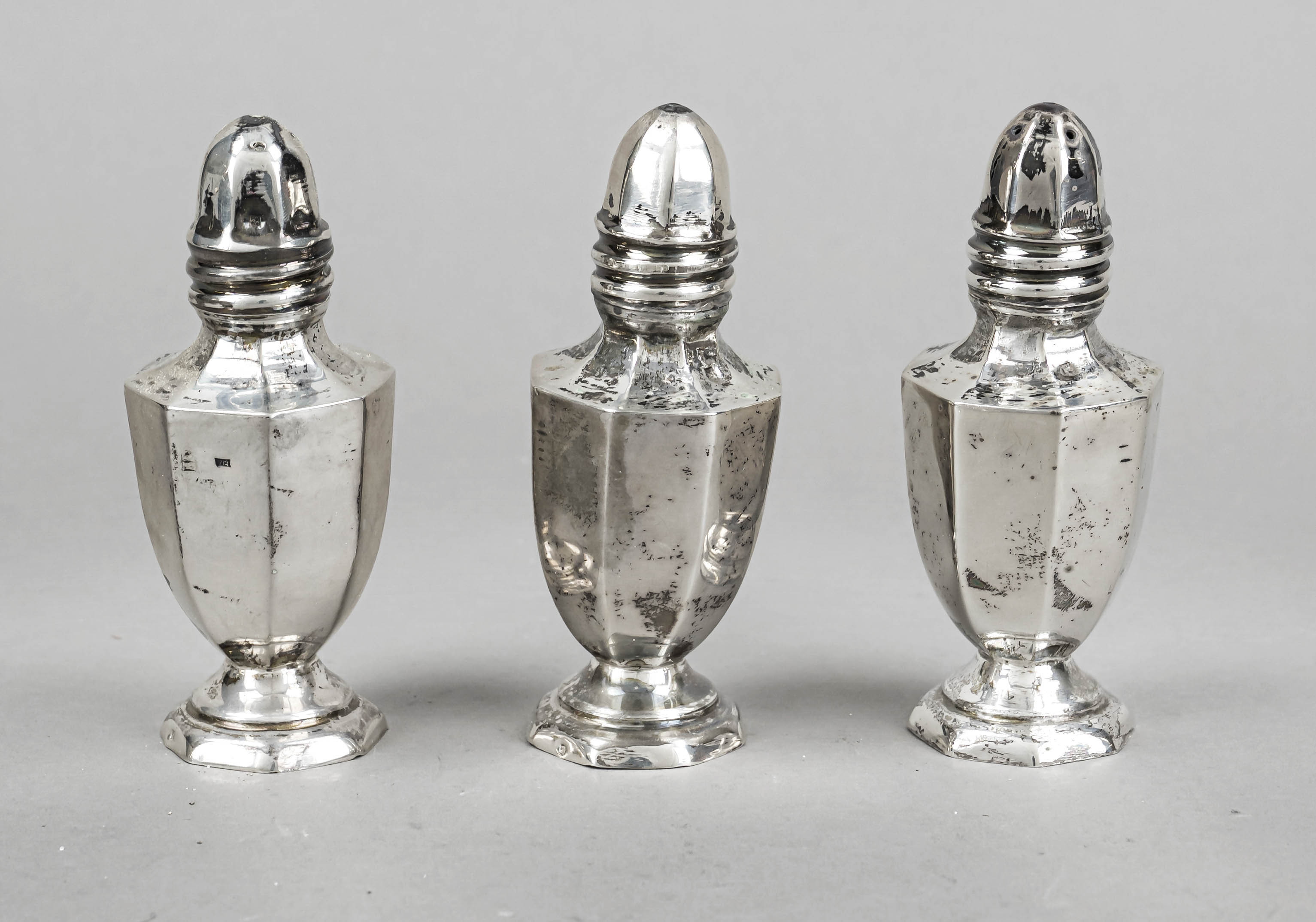 Three shakers, 20th century, hallmarked or tested silver, octagonal stand, angular body, slightly