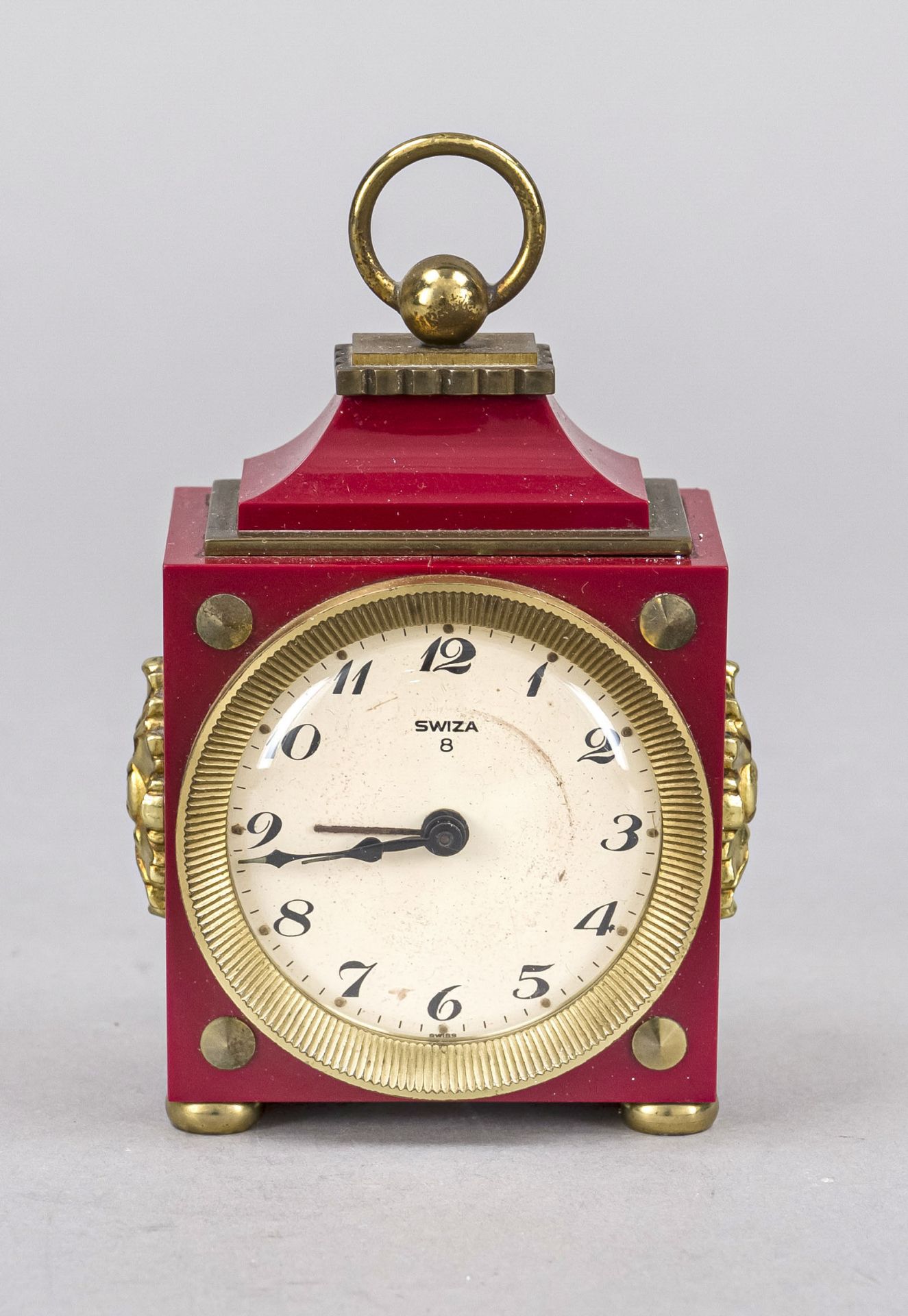 Swiza travel alarm clock, circa 1985, red plastic with gilded decorative elements, top handle,