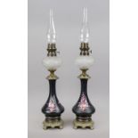 Pair of kerosene lamps, late 19th/early 20th century, vases with flowers on a black ground with