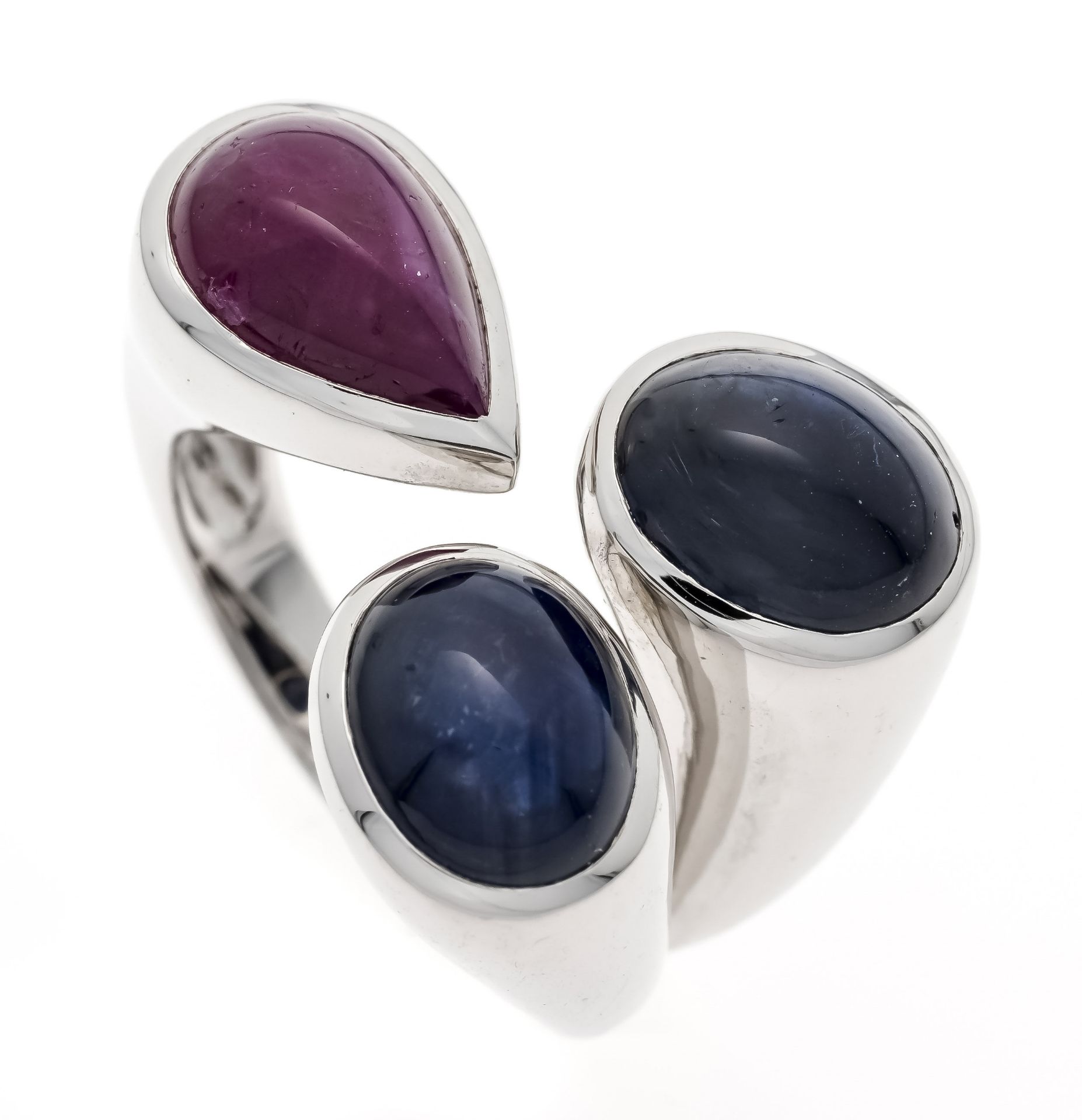 A sapphire and ruby ring, WG 750/000, with two very good oval sapphire cabochons, weighing 9.74 ct