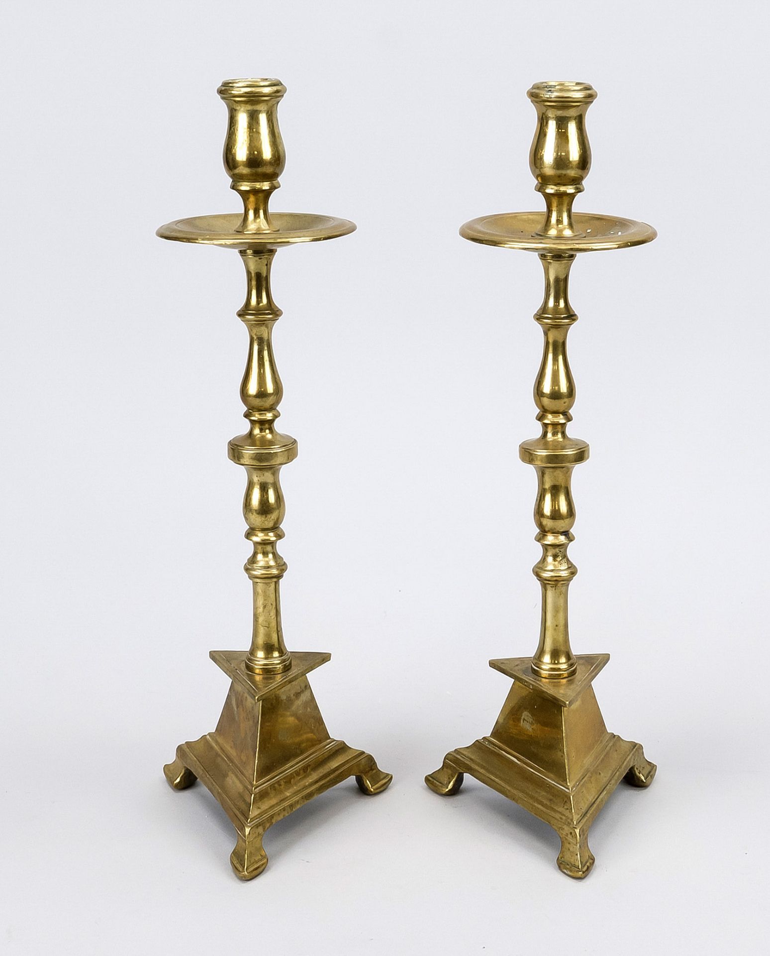 Pair of altar candlesticks, 18th/19th century, brass. Baluster shaft, triangular foot with stepped