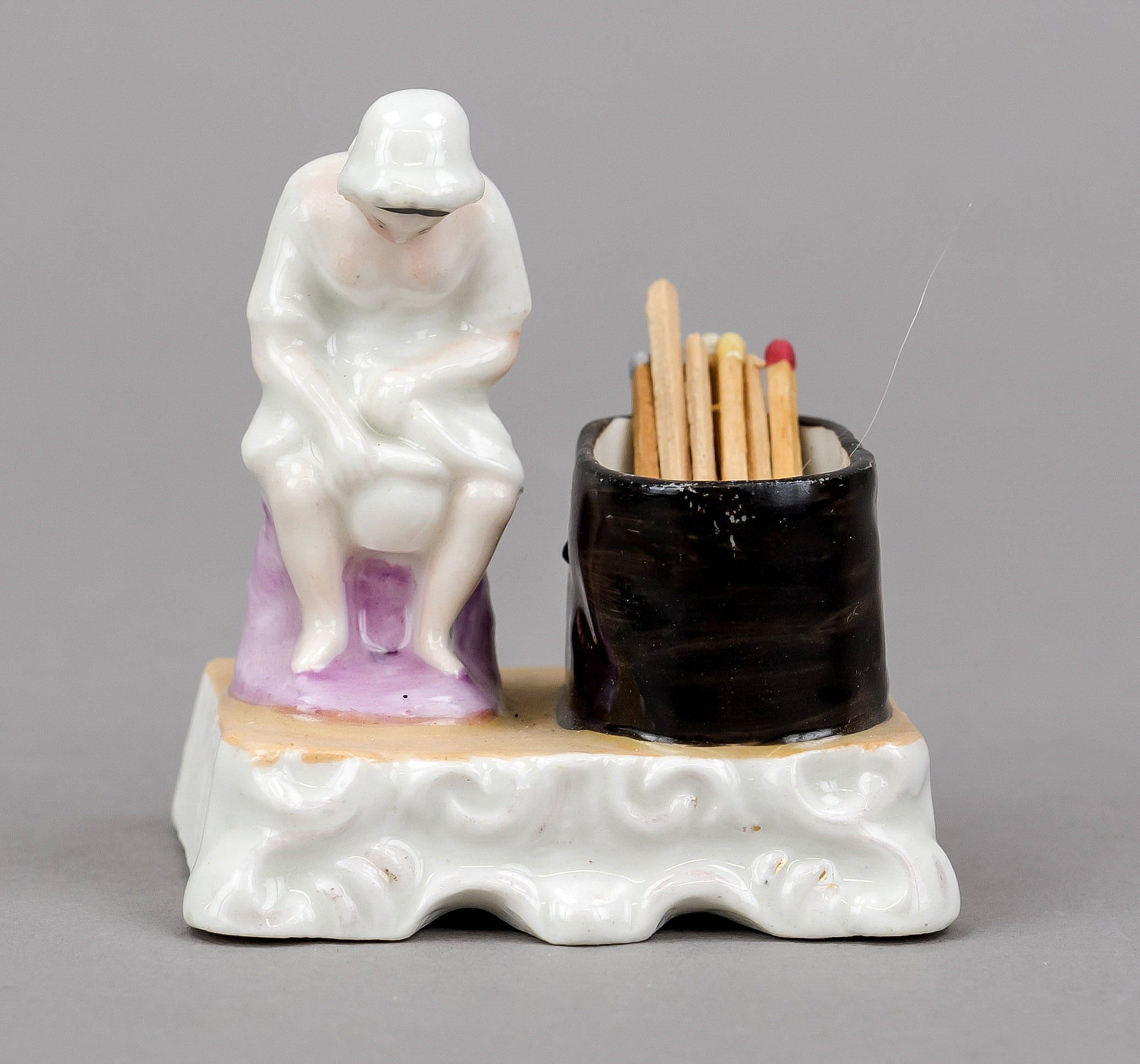 Humorous match holder, late 19th century, polychrome painted and glazed porcelain. Woman on a