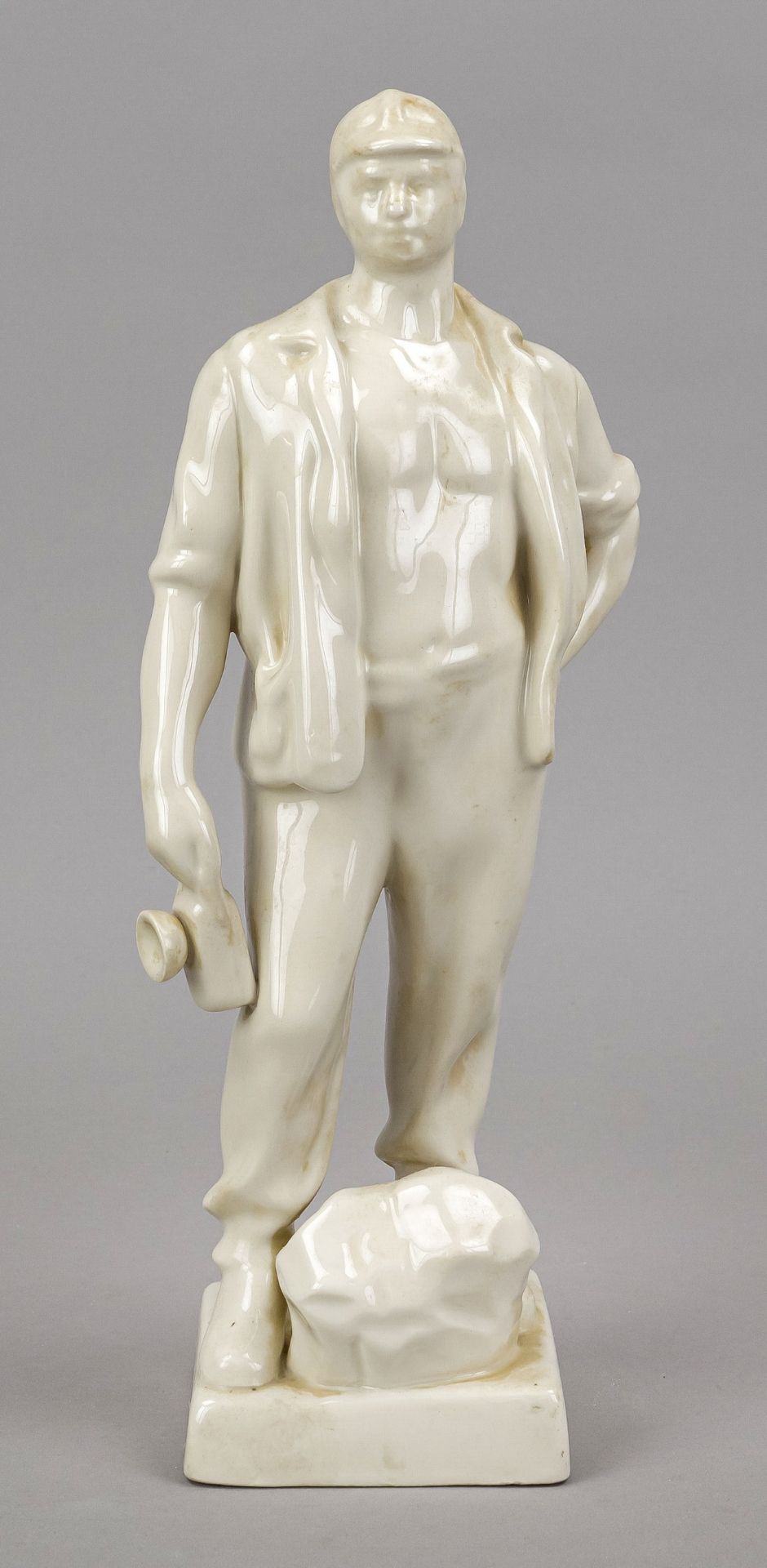 Sculptor mid 20th century, white glazed ceramic of a standing miner, unmarked, h. 35 cm