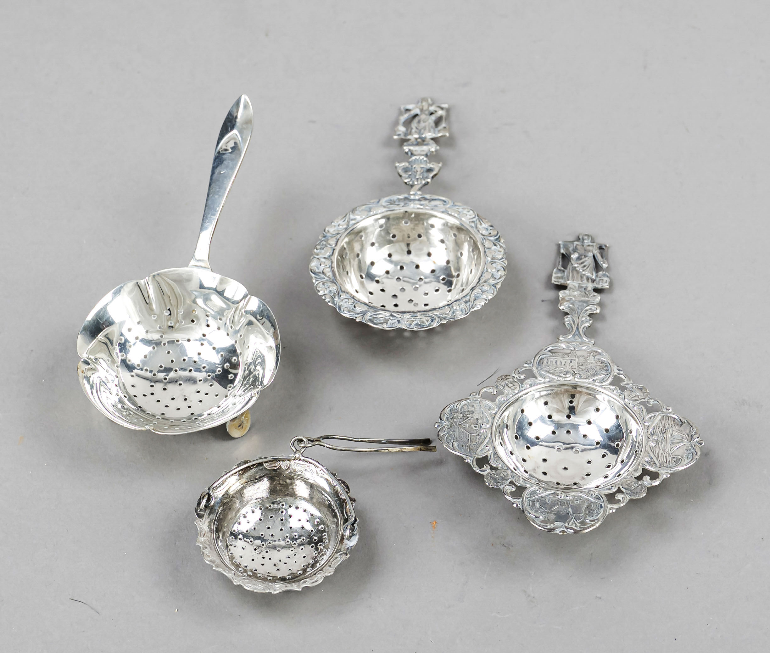 Four tea strainers, 20th century, hallmarked silver, various shapes and sizes, some with relief