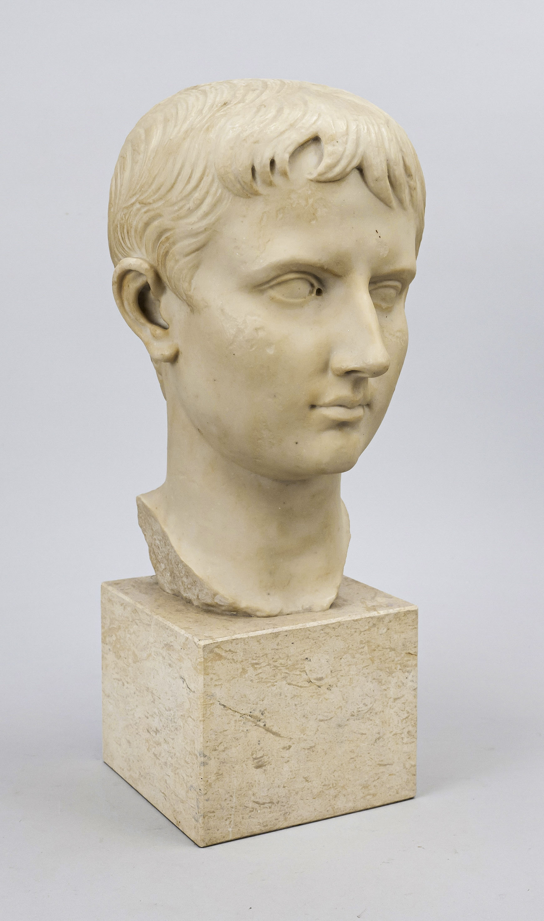 Bust of Julius Caesar, heavy cast stone of the 20th century, on cream-colored marble base, unmarked,