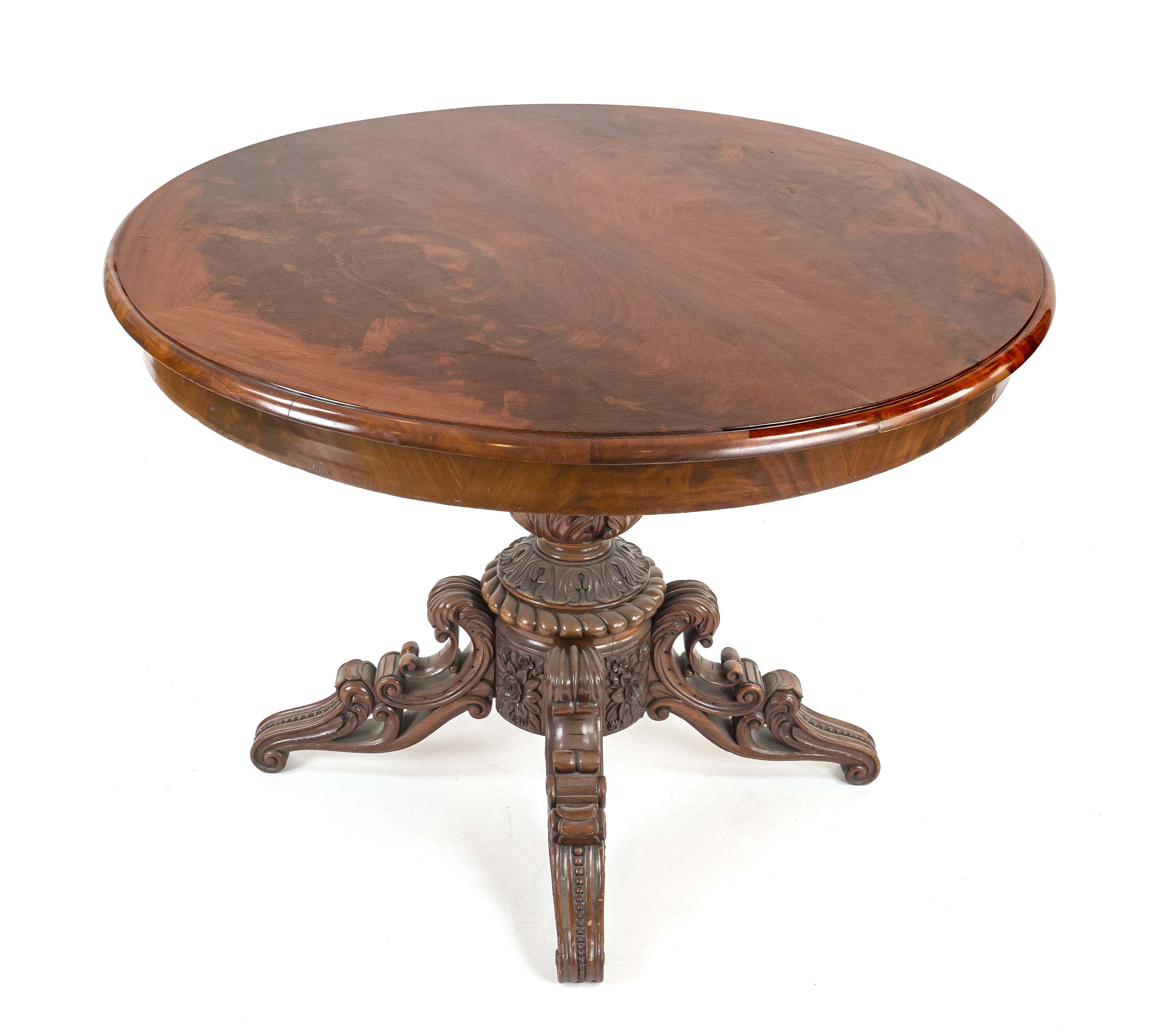 Round dining table, 19th century, mahogany, opulently carved base with four volute feet, h. 76 cm,