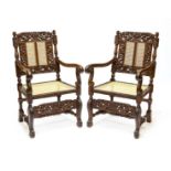 Pair of Baroque-style armchairs, walnut, richly carved, backrests with carved putti, back and seat