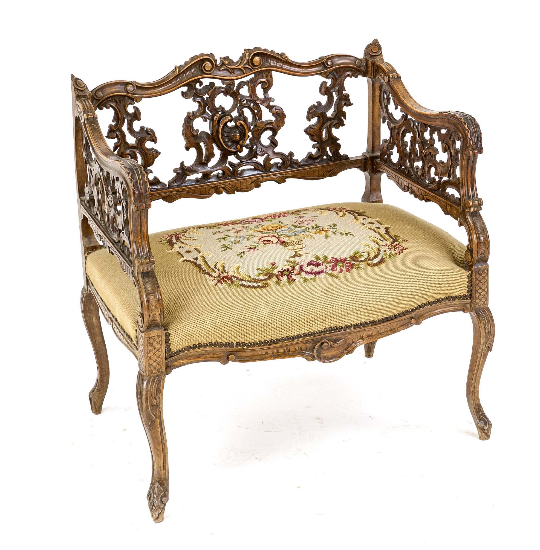Salon chair, 19th century, walnut, heavily openwork carved sides and back on curved legs, tapestry