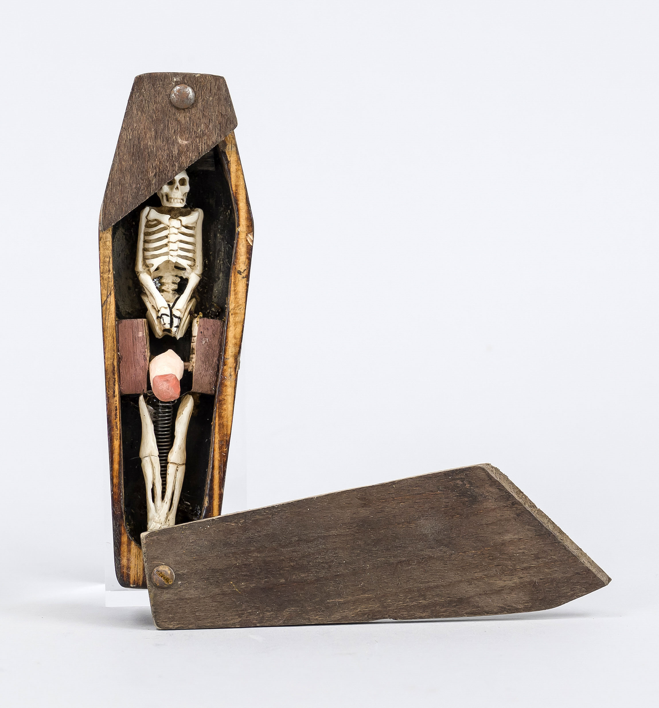 Erotic death, 20th century, wooden coffin with carved leg skeleton, with spring mechanism, phallus