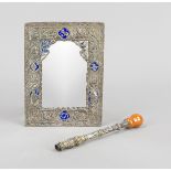 A small rectangular mirror, Oriental, silver tested, partly blue enameled (damaged), figural
