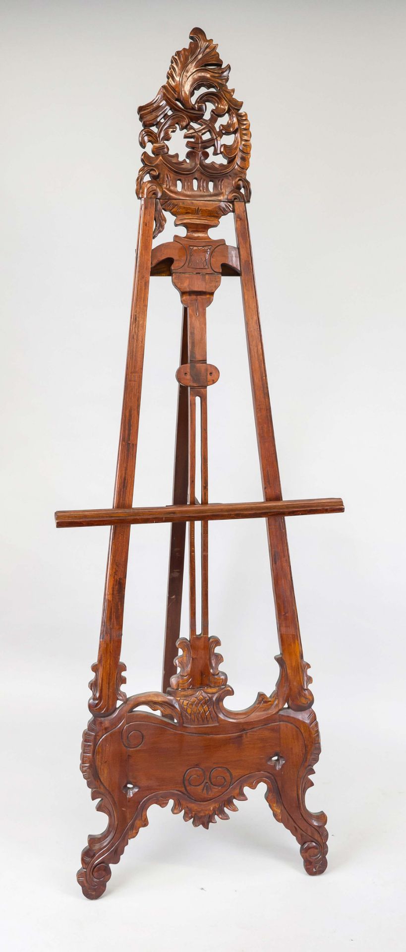 Easel, 20th century, mahogany. Open-worked and ornamentally carved, height-adjustable picture