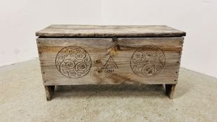 A RUSTIC WOODEN BLANKET BOX WITH HAND CARVED DESIGNS DATED 1961 - W 91CM X D 34CM X H 48CM.