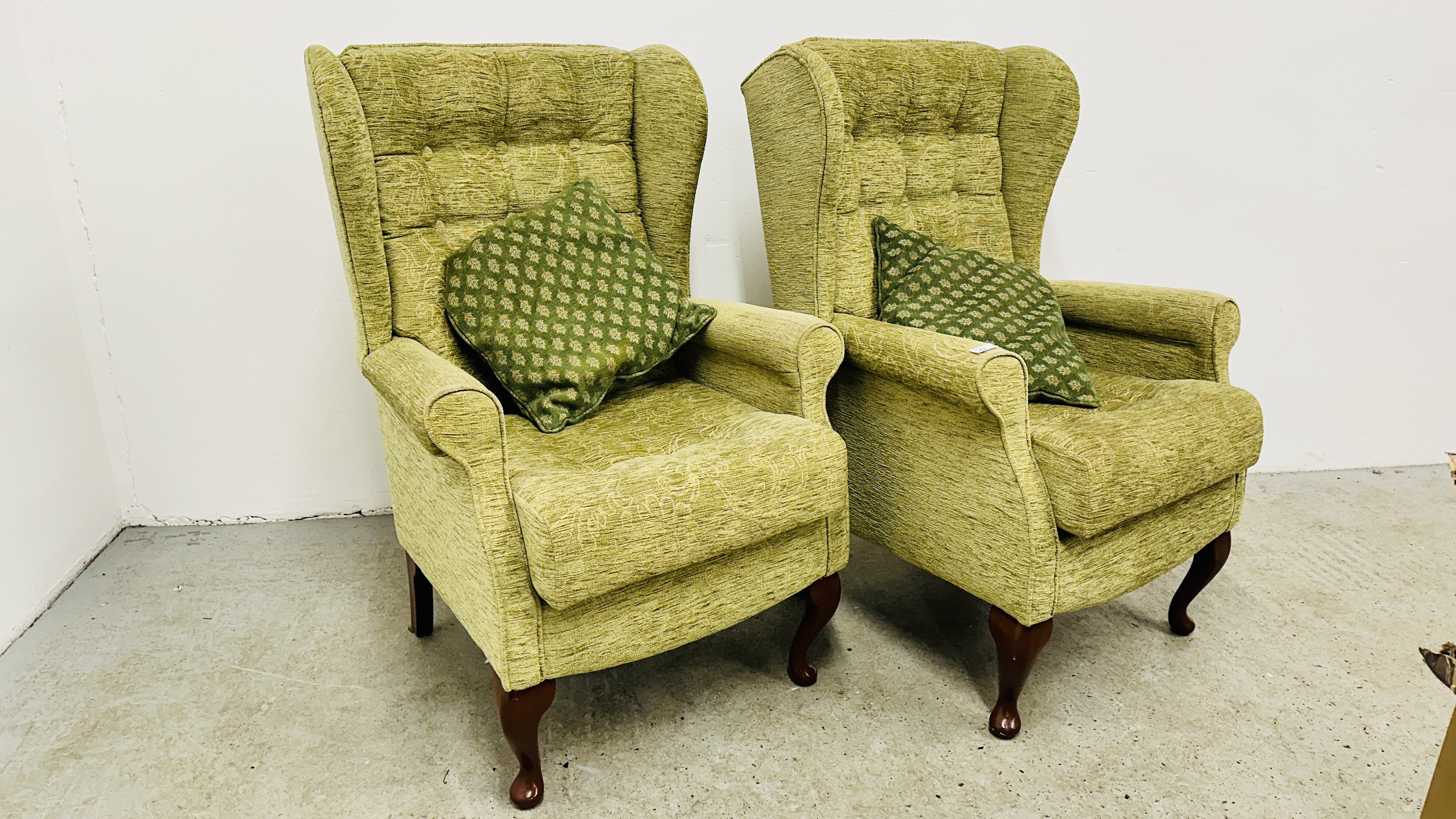 A PAIR OF SHERBORNE GREEN UPHOLSTERED WINGED EASY CHAIRS.