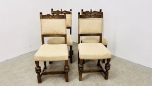 A SET OF FOUR OAK FRAMED DINING CHAIRS WITH CREAM UPHOLSTERED SEATS AND BACKS.