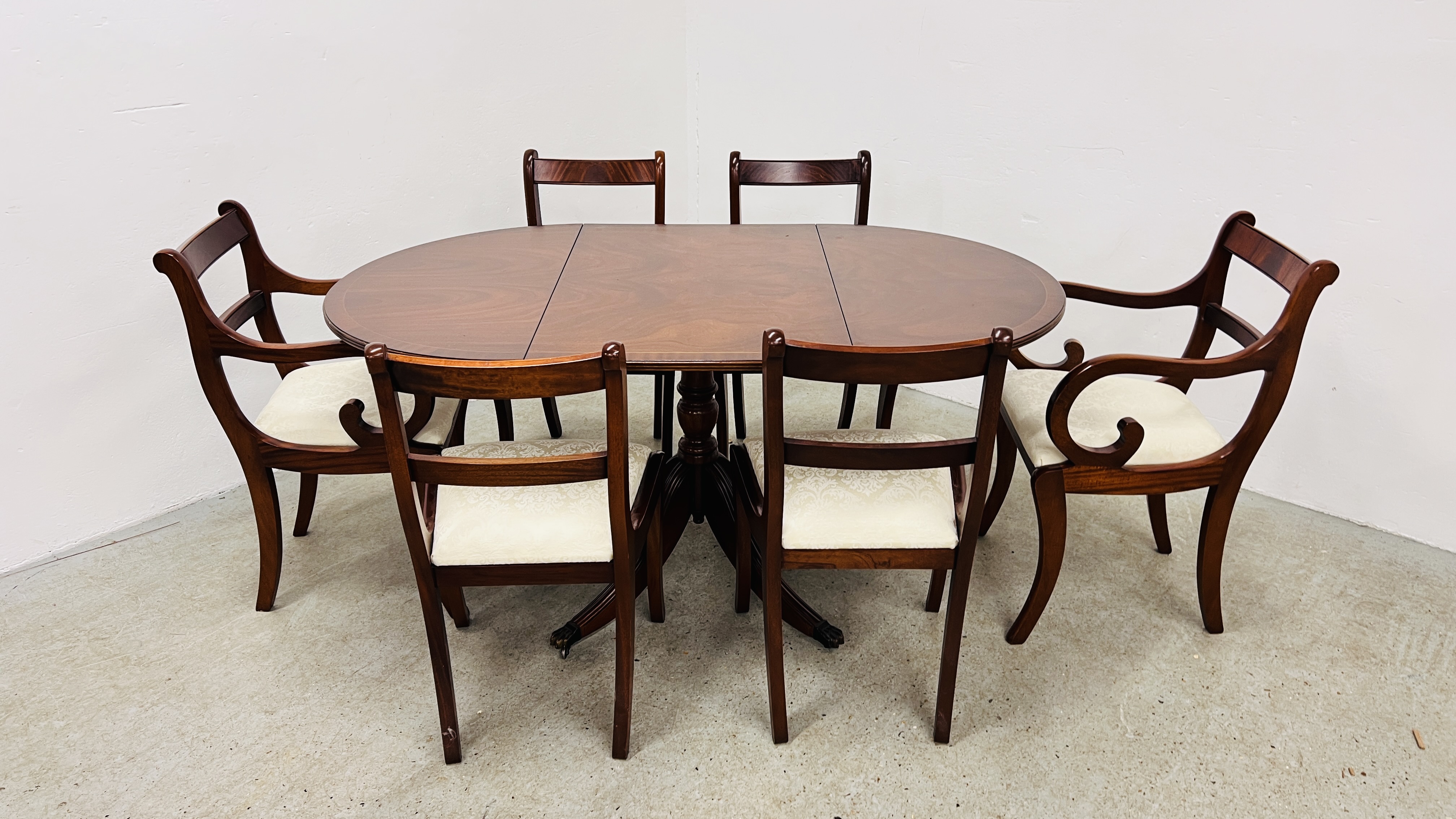 A REPRODUCTION MAHOGANY FINISH EXTENDING DROP LEAF DINING TABLE ALONG WITH 4 MATCHING CHAIRS AND 2