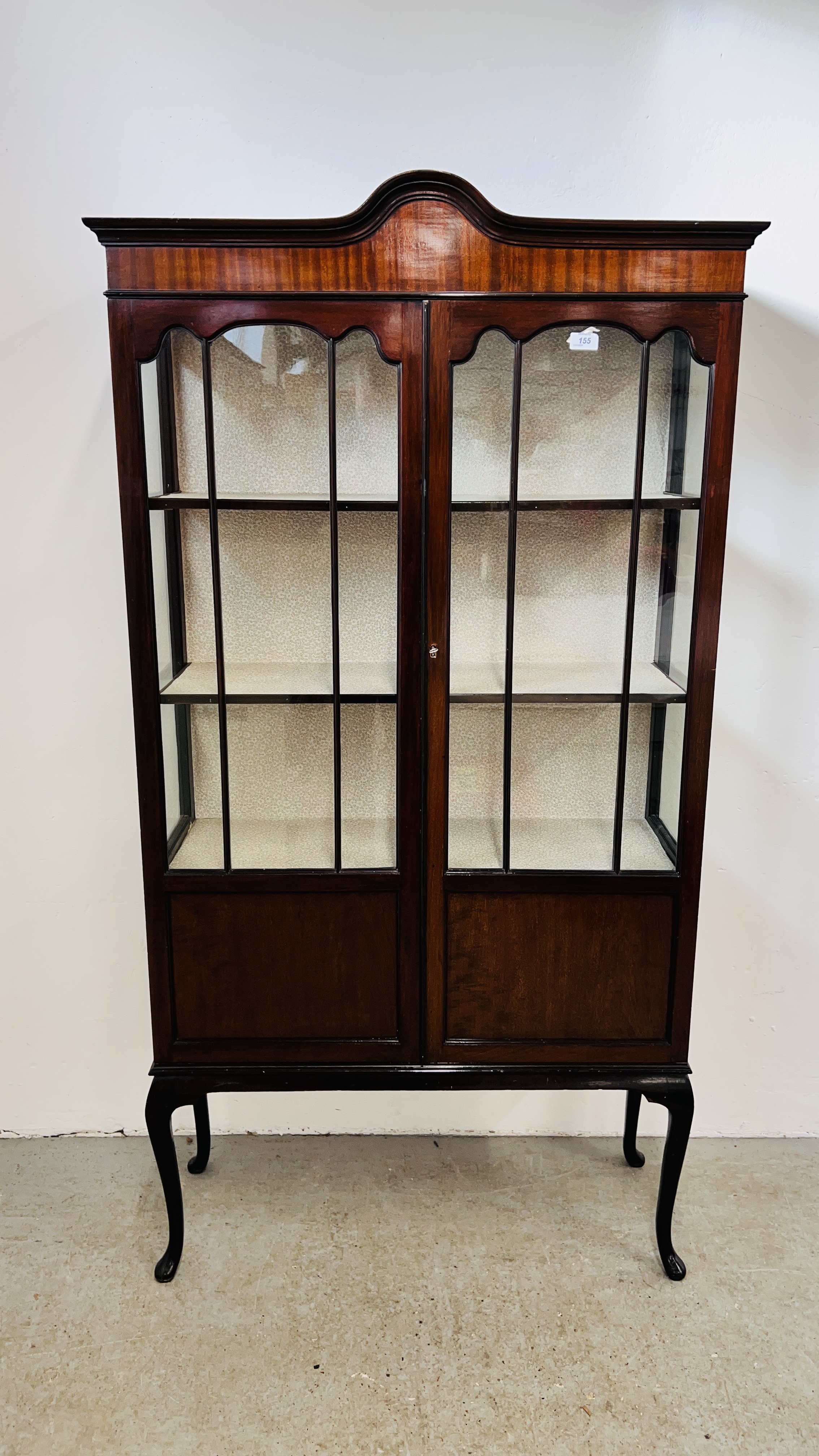 A VINTAGE STYLE MAHOGANY GLAZED TWO DOOR DISPLAY CABINET WITH SHAPED PEDIMENT,