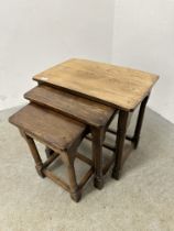 A NEST OF 3 GOOD QUALITY SOLID OAK TABLES.