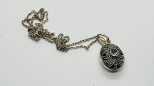 AN OVAL SILVER PENDANT LOCKET SET WITH A CENTRAL AMETHYST AND MARCASITE ON A FINE SILVER CHAIN L