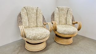 A PAIR OF GOOD QUALITY BAMBOO FRAMED RELAXER CHAIRS WITH ROCKING AND REVOLVING ACTION.