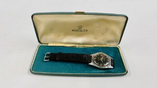 A VINTAGE WRIST WATCH MARKED SERVICES 17 JEWELS SHOCK PROOF ON BLACK LEATHER STRAP IN ORIGINAL