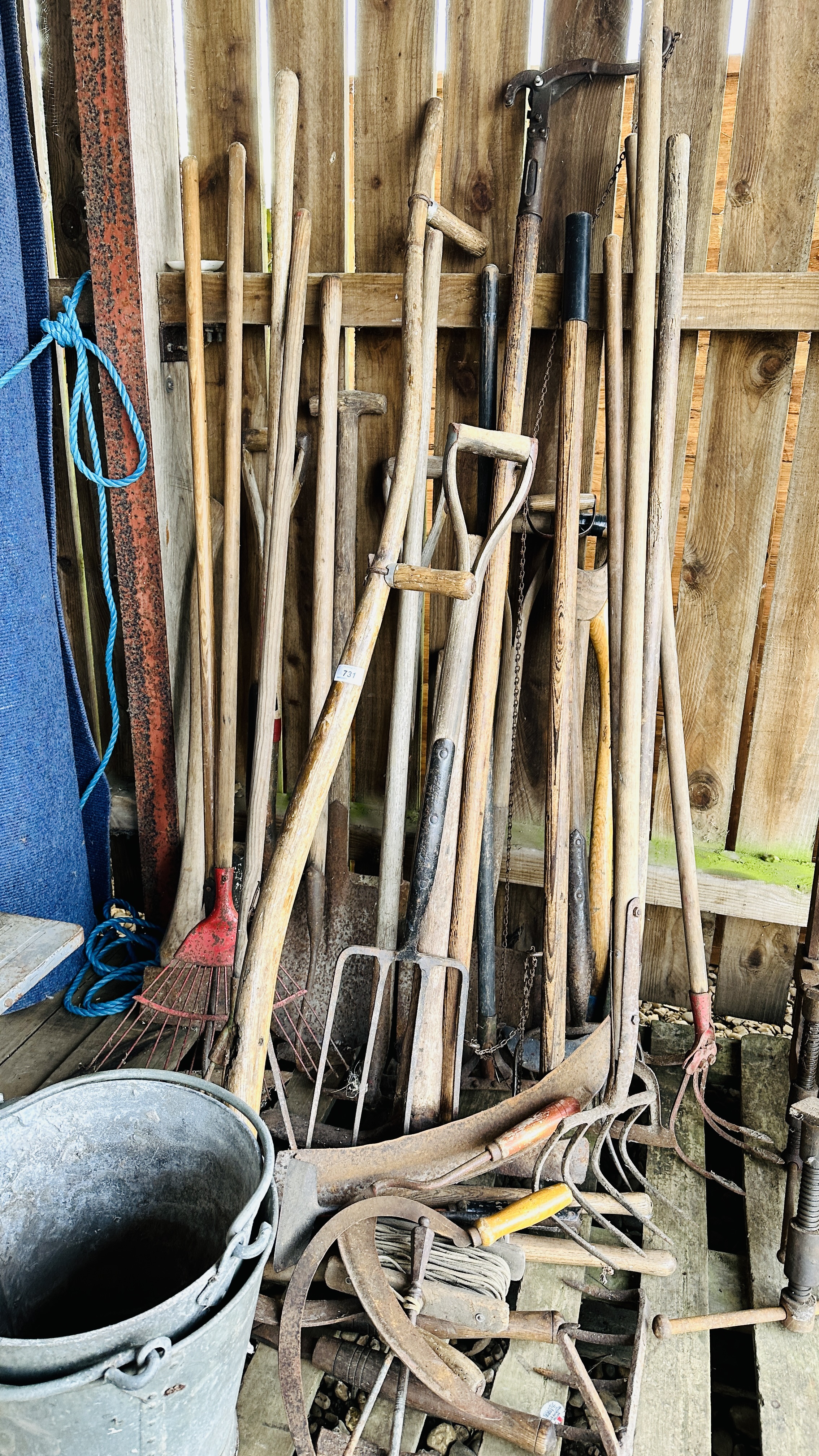 A LARGE QUANTITY OF VINTAGE GARDENING HAND TOOLS TO INCLUDE SPADES, SHOVELS, SYTHES,