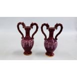 A PAIR OF RED GLAZED C19TH TWO HANDLED VASES WITH DRAGON DESIGNED HEAD SUPPORTS - HEIGHT 24CM.