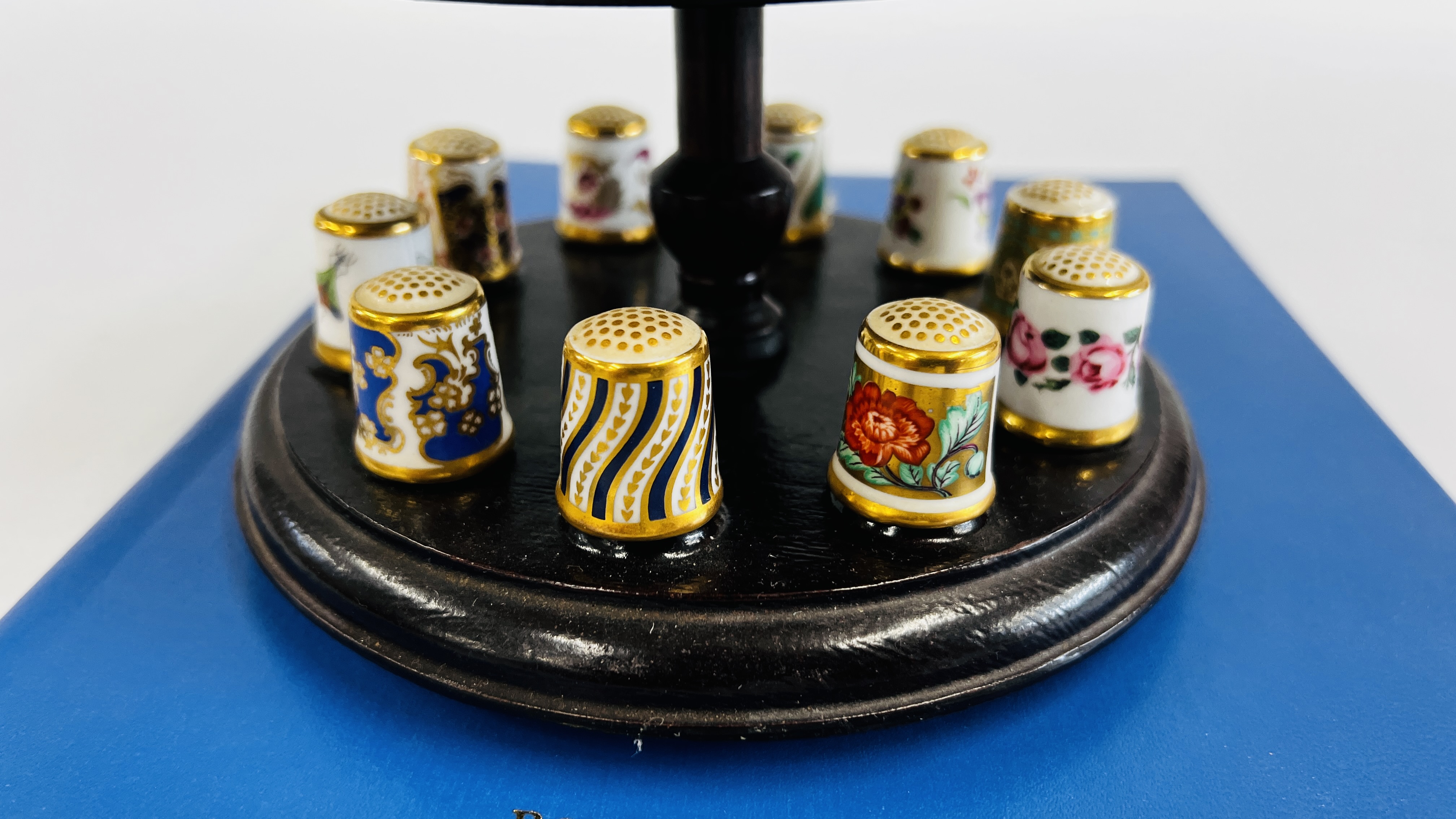 A COLLECTION OF 15 ROYAL CROWN DERBY THIMBLES ON A THIMBLE STAND WITH A PIN CUSHION INSET ALONG - Image 6 of 9