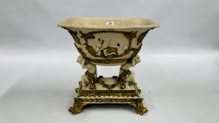 AN ELABORATE RESIN CENTRE PIECE SUPPORTED BY CHERUBS DECORATED WITH GILT FOLIAGE.