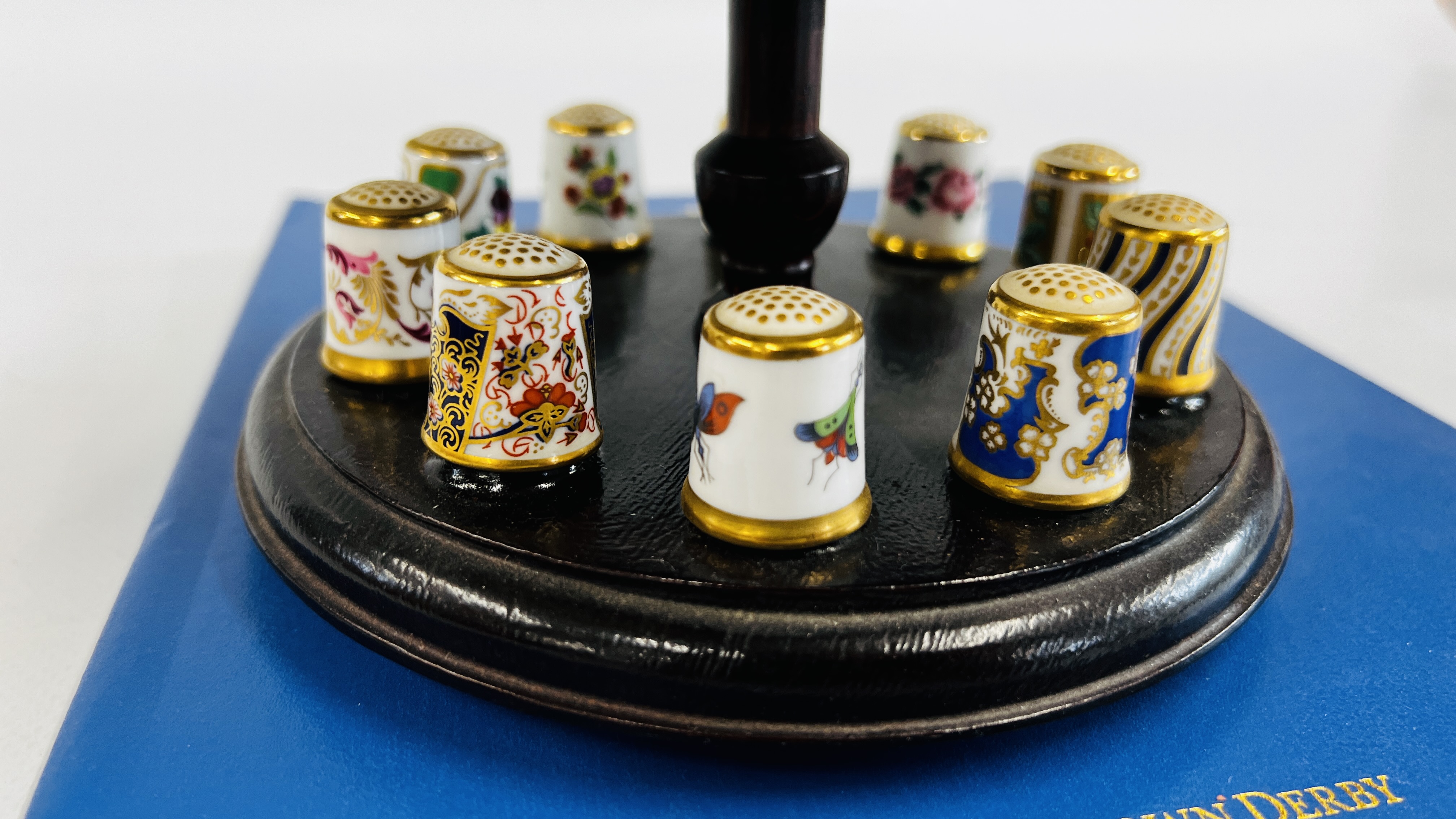 A COLLECTION OF 15 ROYAL CROWN DERBY THIMBLES ON A THIMBLE STAND WITH A PIN CUSHION INSET ALONG - Image 4 of 9