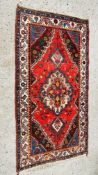 A RED/BLUE/BROWN PATTERNED EASTERN RUG, 193 X 105CM.