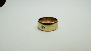 A GOLD BAND RING MARKED 375 SET WITH SINGLE DIAMOND IN STAR SETTING SIZE T/U.