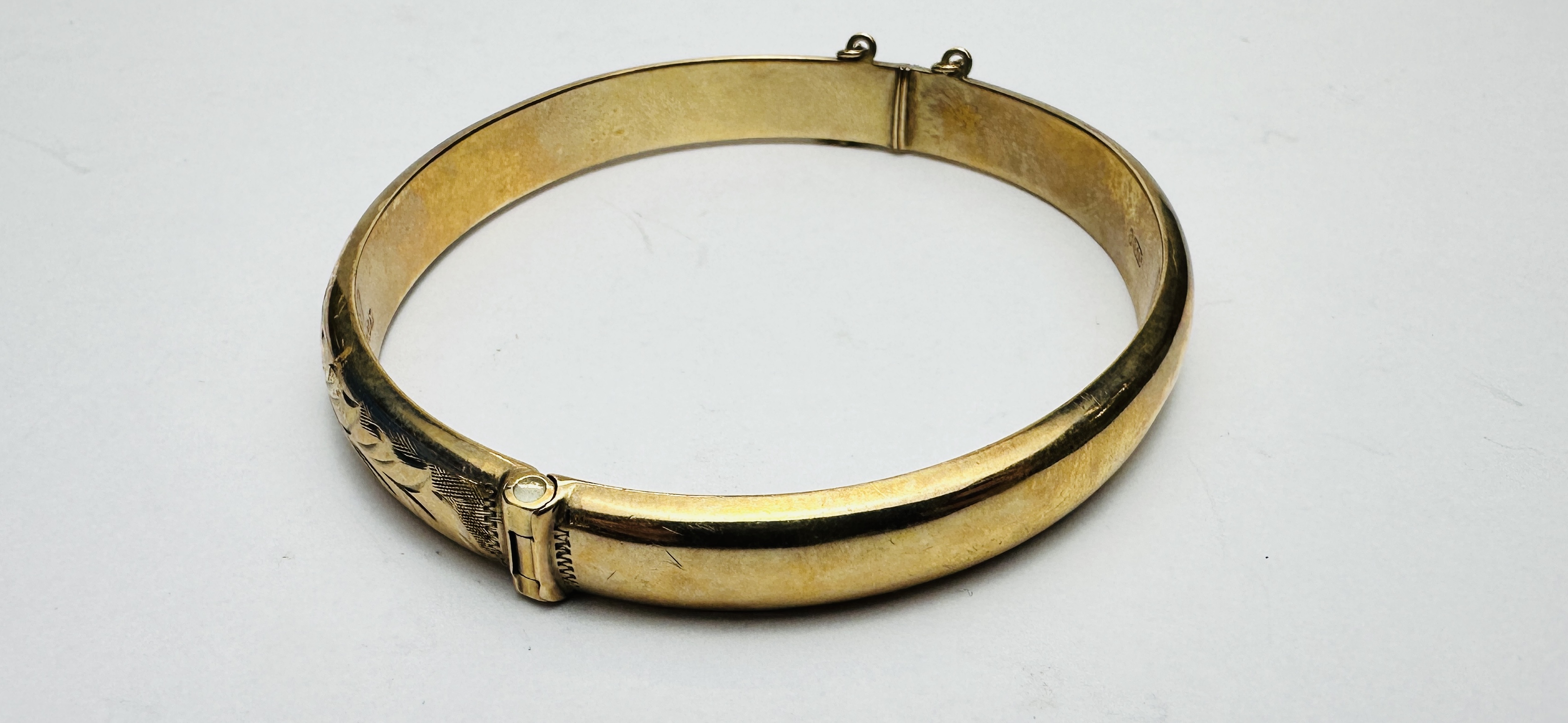 A 9CT GOLD HINGED BANGLE WITH SAFETY CHAIN AND CHASED DECORATION. - Image 5 of 6