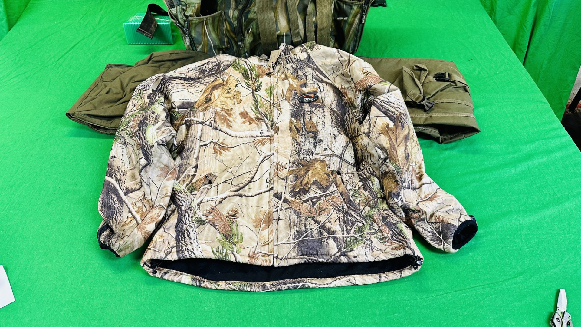 NASH CAMOUFLAGE MULTI POCKET BACK PACK ALONG WITH T F GEAR CAMOUFLAGE JACKET SIZE L AND ROD BAG. - Image 2 of 11