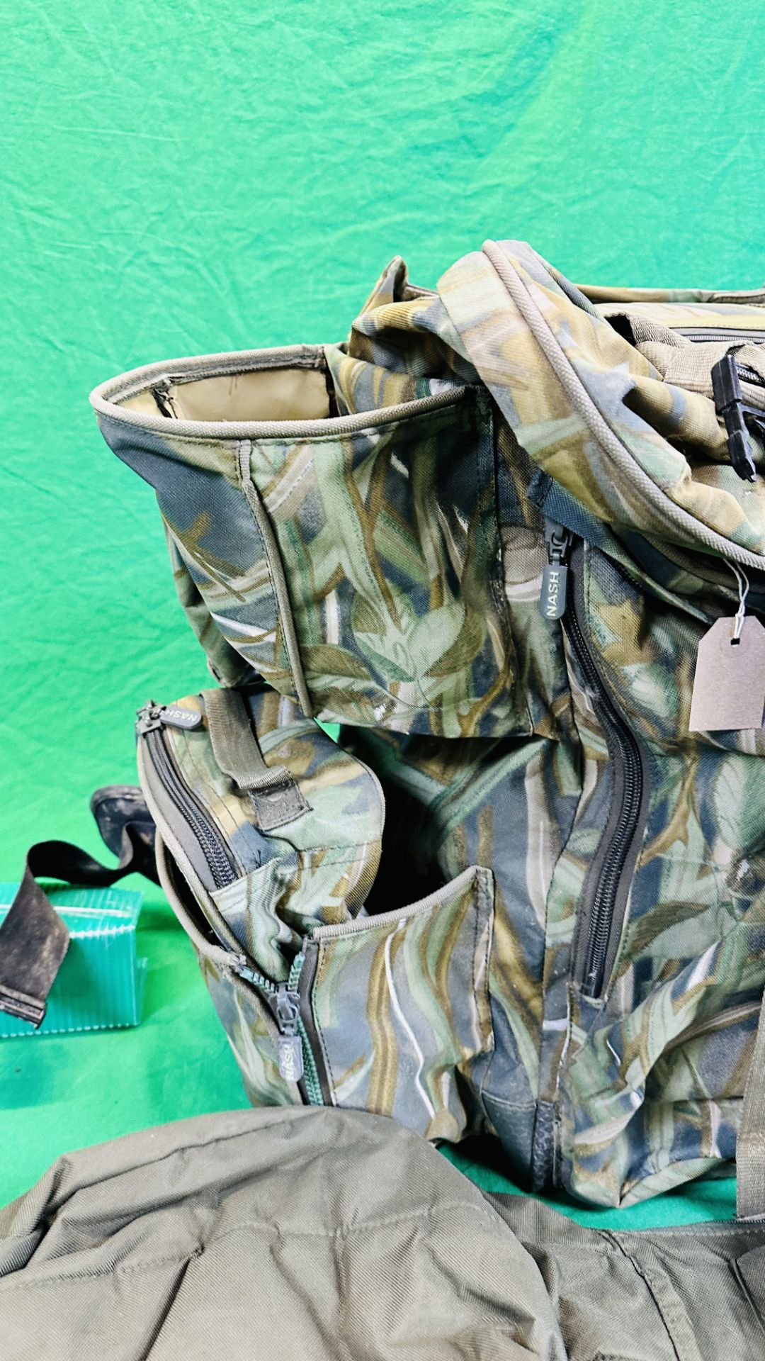 NASH CAMOUFLAGE MULTI POCKET BACK PACK ALONG WITH T F GEAR CAMOUFLAGE JACKET SIZE L AND ROD BAG. - Image 5 of 11