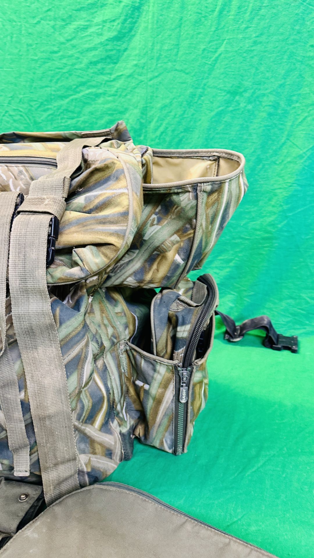 NASH CAMOUFLAGE MULTI POCKET BACK PACK ALONG WITH T F GEAR CAMOUFLAGE JACKET SIZE L AND ROD BAG. - Image 7 of 11